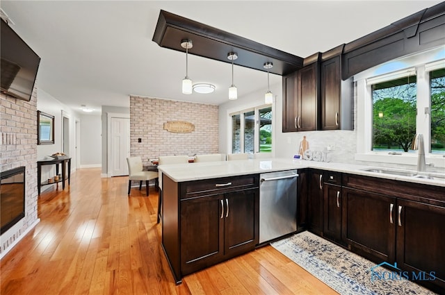 685 N Main St, Arlington, OH 45814 - kitchen with dishwasher, a sink, light wood-style flooring, a peninsula, and light countertops