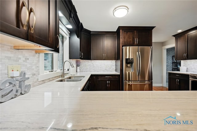685 N Main St, Arlington, OH 45814 - kitchen with stainless steel appliances, a sink, backsplash, dark brown cabinets, and wood finished floors