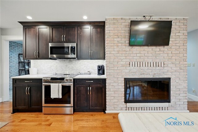 685 N Main St, Arlington, OH 45814 - kitchen featuring stainless steel appliances, light wood-style flooring, decorative backsplash, dark brown cabinets, and recessed lighting