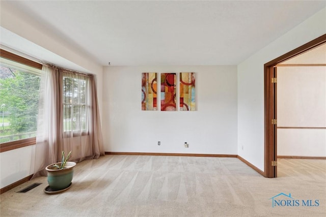empty room featuring carpet and baseboards