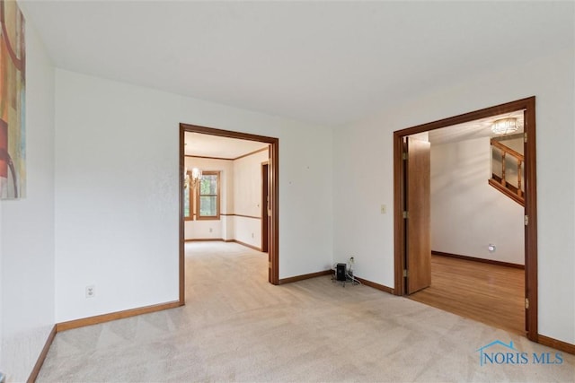 unfurnished room with light carpet and baseboards