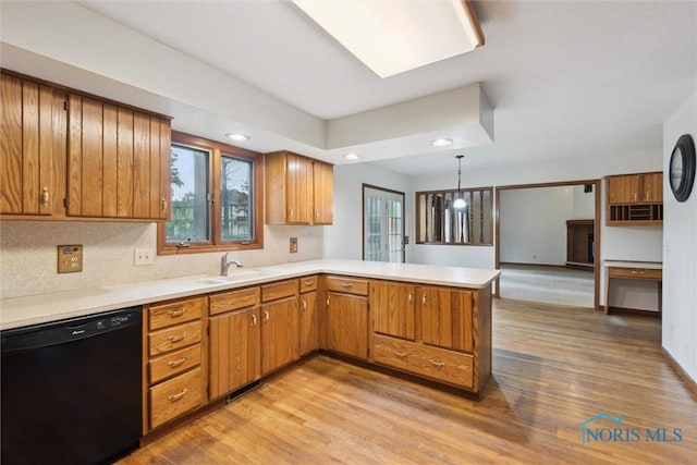 kitchen with dishwasher, light countertops, brown cabinets, a peninsula, and recessed lighting