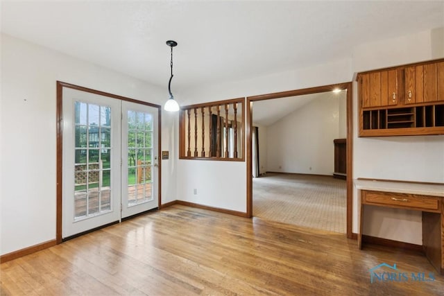 unfurnished dining area with light wood-style flooring and baseboards