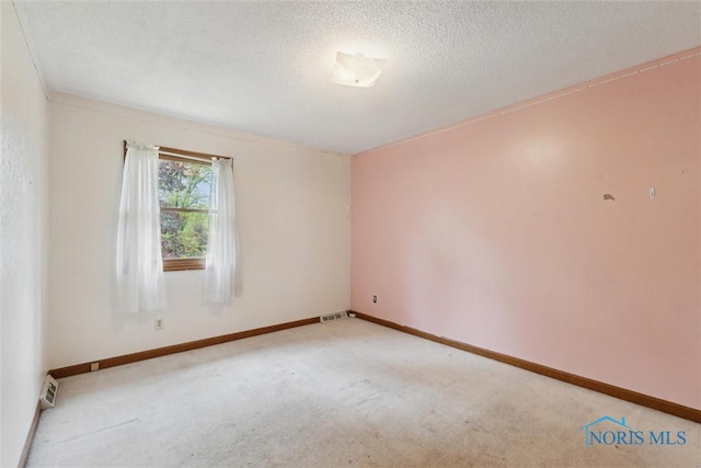 unfurnished room with carpet, a textured ceiling, and baseboards