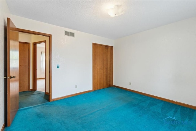 unfurnished bedroom featuring carpet flooring, a closet, baseboards, and a textured ceiling