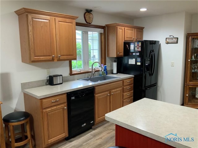 109 Rivers Edge Ln Unit C, Upper Sandusky, OH 43351 - kitchen with black appliances, a sink, light countertops, light wood-type flooring, and brown cabinets