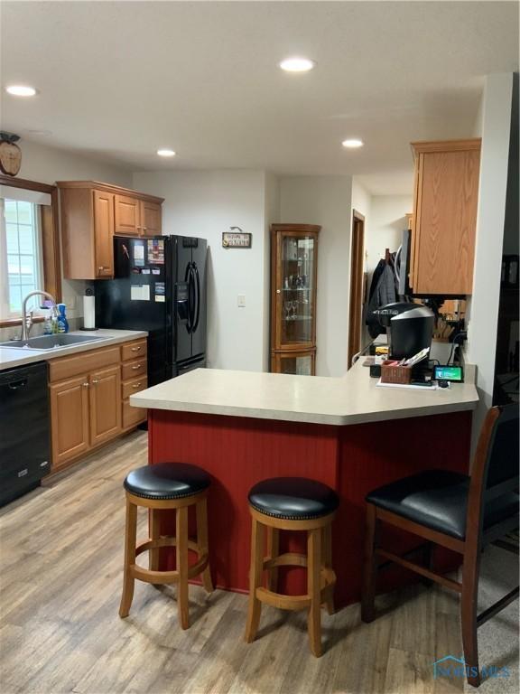 109 Rivers Edge Ln Unit C, Upper Sandusky, OH 43351 - kitchen with black appliances, a sink, light wood finished floors, a peninsula, and recessed lighting