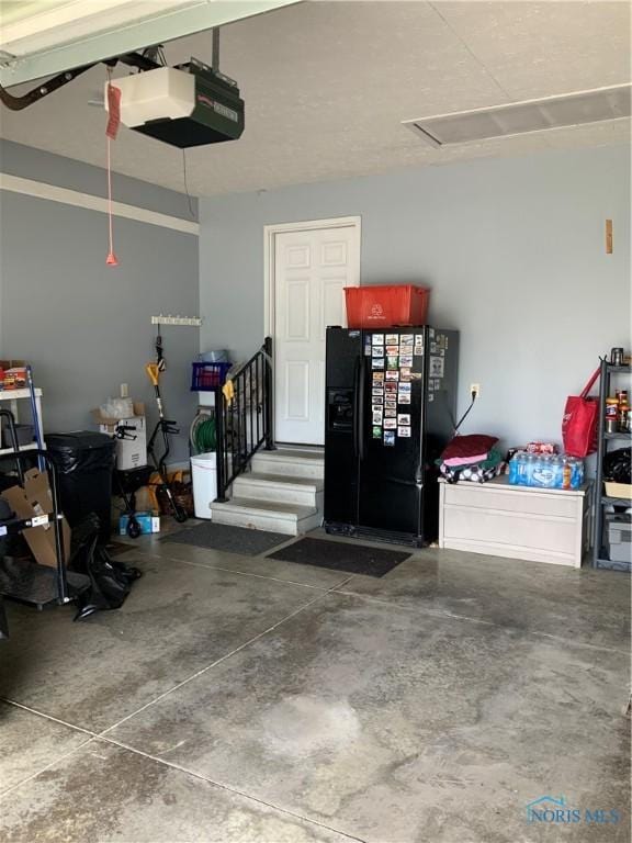 109 Rivers Edge Ln Unit C, Upper Sandusky, OH 43351 - garage with black fridge with ice dispenser and a garage door opener
