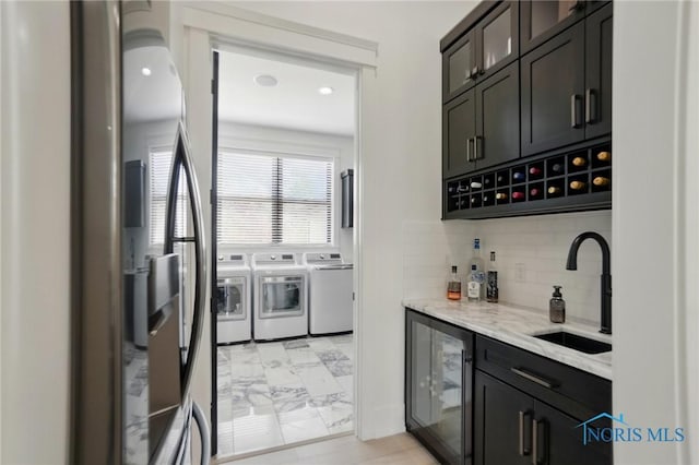 8440 E Woodland Trl, Findlay, OH 45840 - indoor dry bar with separate washer and dryer, wine cooler, light marble finish floors, decorative backsplash, and stainless steel refrigerator with ice dispenser