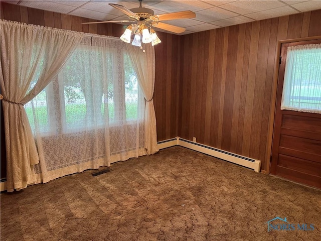 165 5th St, Mcclure, OH 43534 - carpeted spare room featuring baseboard heating, wooden walls, and ceiling fan