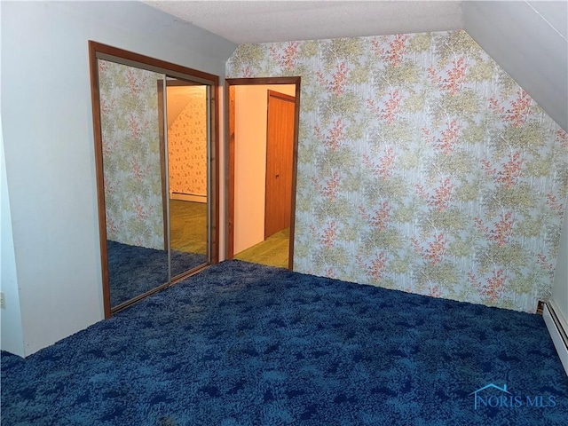165 5th St, Mcclure, OH 43534 - unfurnished bedroom featuring carpet flooring, baseboard heating, wallpapered walls, and vaulted ceiling