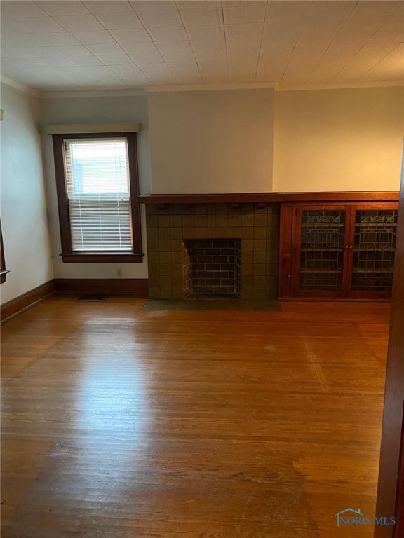 862 Prouty Ave, Toledo, OH 43609 - unfurnished living room with crown molding, wood finished floors, baseboards, and a fireplace