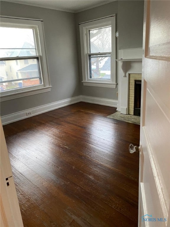 862 Prouty Ave, Toledo, OH 43609 - unfurnished living room featuring hardwood / wood-style flooring, baseboards, a fireplace, and crown molding