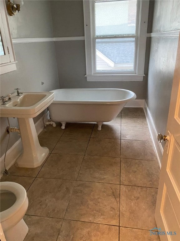 862 Prouty Ave, Toledo, OH 43609 - full bathroom with a soaking tub, toilet, tile patterned floors, and baseboards