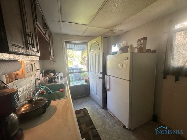 2111 Elm St, Toledo, OH 43608 - kitchen featuring freestanding refrigerator, light countertops, a sink, and dark brown cabinets