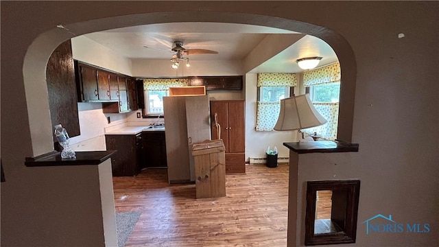 203 E Ash St, Continental, OH 45831 - kitchen featuring a ceiling fan, arched walkways, light wood-style flooring, and dark brown cabinets