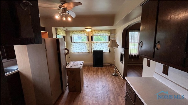 203 E Ash St, Continental, OH 45831 - kitchen featuring ceiling fan, arched walkways, wood finished floors, and baseboard heating