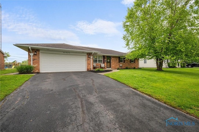 394 Overlook Dr, Waterville, OH 43566 - ranch-style house with asphalt driveway, brick siding, a front yard, and a garage