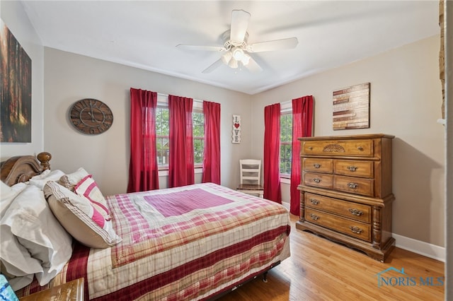 bedroom featuring light wood finished floors, baseboards, and ceiling fan