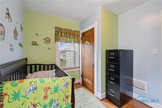 bedroom featuring wood finished floors and baseboards
