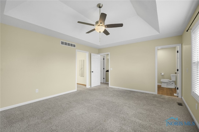 7060 Joannes Way, Maumee, OH 43537 - unfurnished bedroom featuring carpet floors, a raised ceiling, ensuite bathroom, baseboards, and multiple windows