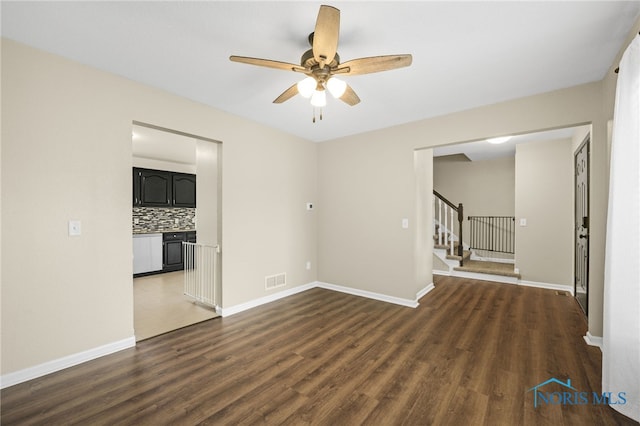 7060 Joannes Way, Maumee, OH 43537 - empty room featuring dark wood-type flooring, stairs, a ceiling fan, and baseboards