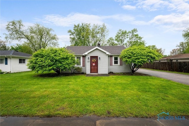 single story home with a chimney and asphalt driveway