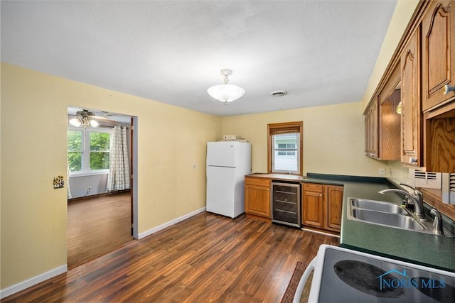 kitchen with beverage cooler, freestanding refrigerator, a sink, and healthy amount of natural light