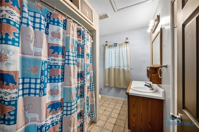bathroom featuring a textured ceiling, vanity, baseboards, and a shower with shower curtain