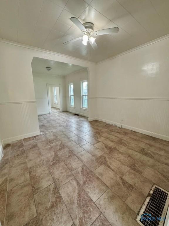 2108 N Michigan St, Toledo, OH 43611 - unfurnished room with crown molding, a ceiling fan, and a wainscoted wall