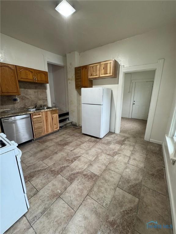 2108 N Michigan St, Toledo, OH 43611 - kitchen with freestanding refrigerator, stove, dishwasher, decorative backsplash, and brown cabinetry