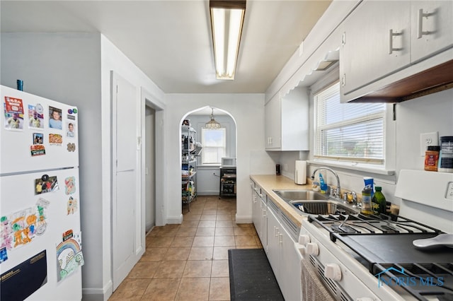 2352 108th St, Toledo, OH 43611 - kitchen with white appliances, white cabinetry, light tile patterned flooring, and healthy amount of natural light