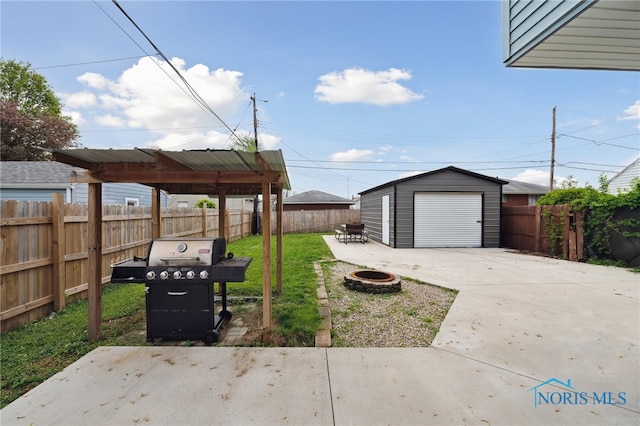 2352 108th St, Toledo, OH 43611 - fenced backyard with an outdoor fire pit, a detached garage, driveway, an outdoor structure, and a patio area