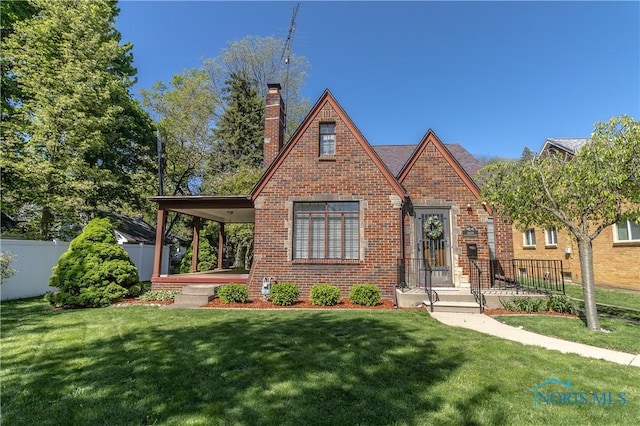 tudor house featuring brick siding and a chimney
