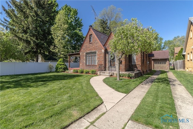 tudor-style house with brick siding, concrete driveway, and a garage