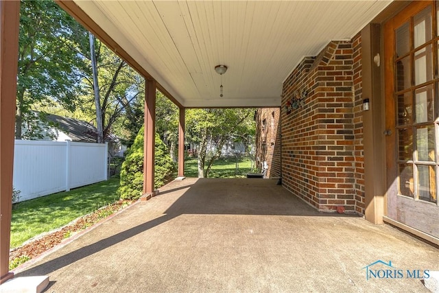 view of patio / terrace with fence and an attached carport