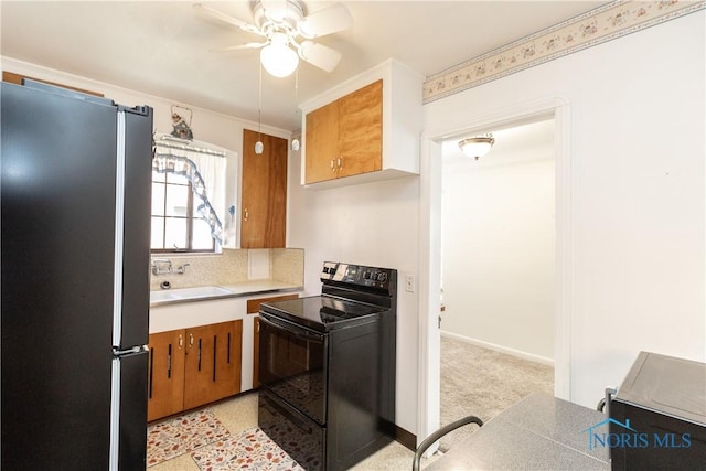 kitchen featuring electric range, freestanding refrigerator, a sink, ceiling fan, and tasteful backsplash