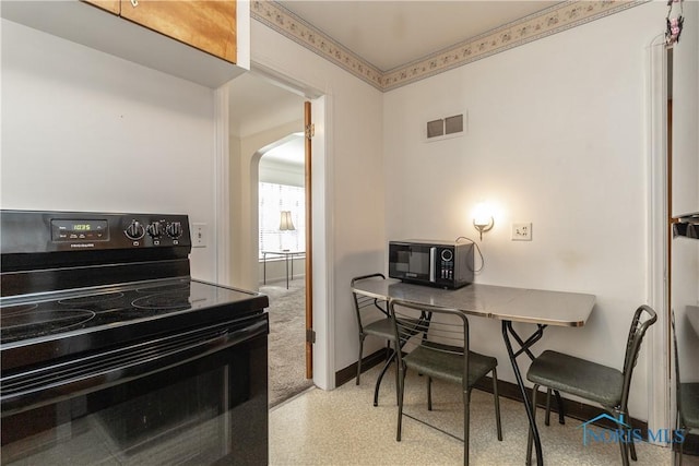 kitchen with black appliances, arched walkways, and baseboards