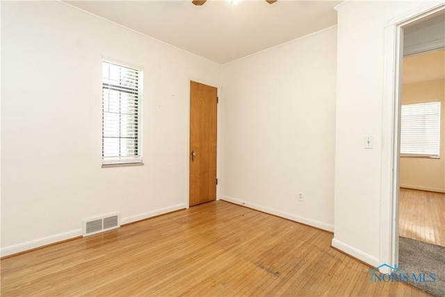 empty room with light wood finished floors, ceiling fan, baseboards, and healthy amount of natural light