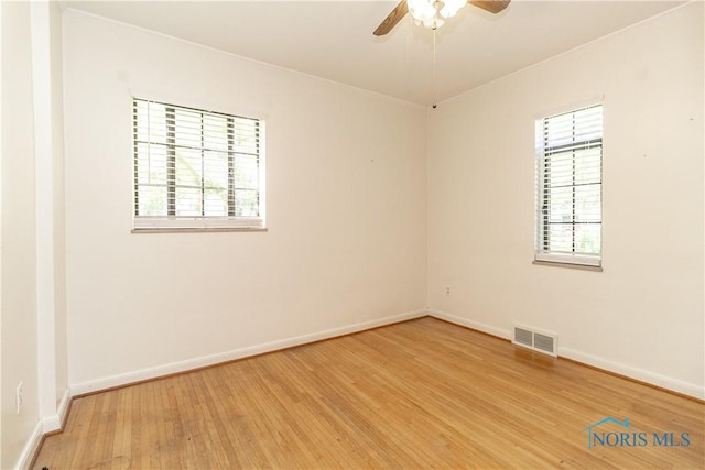 unfurnished room with light wood-style floors, a ceiling fan, and baseboards
