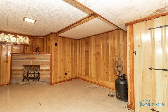 unfurnished living room with tile patterned floors, a fireplace, and wooden walls
