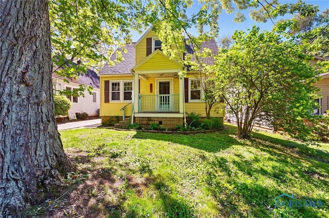 view of front of house with a front yard and roof with shingles