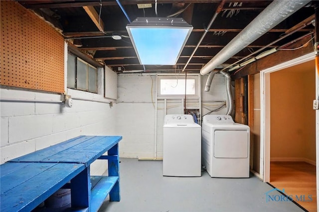 clothes washing area with independent washer and dryer and concrete block wall