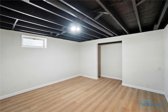 basement featuring wood finished floors and baseboards
