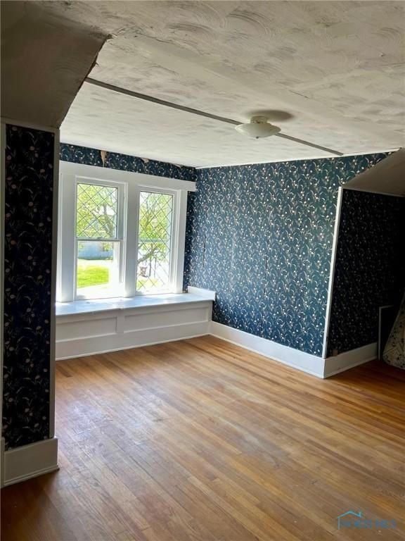 5907 N Berkey Southern Rd, Berkey, OH 43504 - empty room with wallpapered walls, wood finished floors, and baseboards