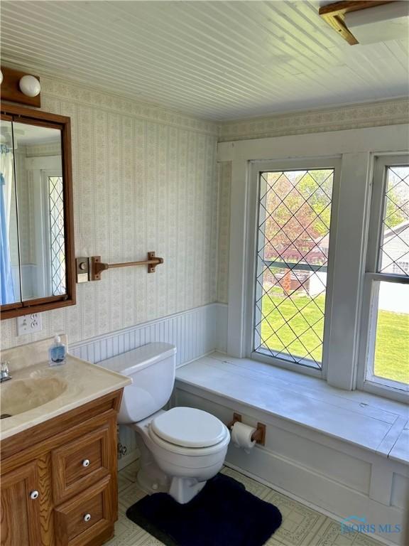 5907 N Berkey Southern Rd, Berkey, OH 43504 - bathroom featuring wallpapered walls, toilet, vanity, and a wainscoted wall