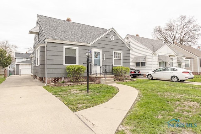3134 Cragmoor Ave, Toledo, OH 43614 - view of front of property featuring roof with shingles, a front yard, and a chimney