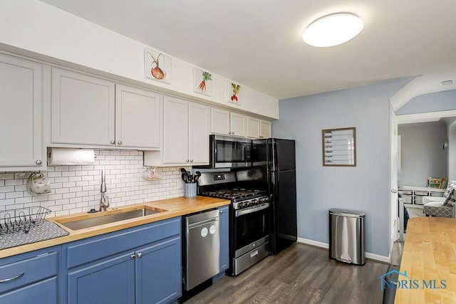 3134 Cragmoor Ave, Toledo, OH 43614 - kitchen with butcher block countertops, stainless steel appliances, a sink, tasteful backsplash, and dark wood-style flooring