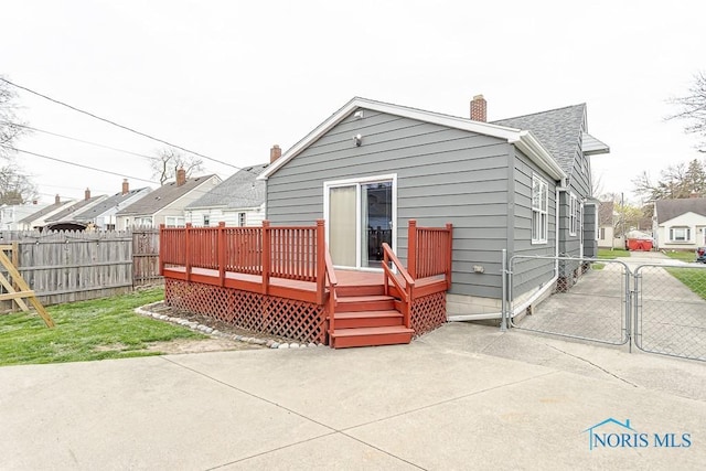 3134 Cragmoor Ave, Toledo, OH 43614 - back of house with fence, a gate, a patio area, a wooden deck, and a chimney