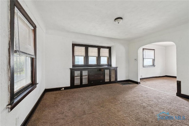 1908 Parkdale Ave, Toledo, OH 43607 - unfurnished room with arched walkways, carpet flooring, and baseboards